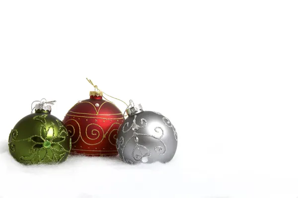 Červené, zelené a stříbrné vánoční koule na sněhu — Stock fotografie