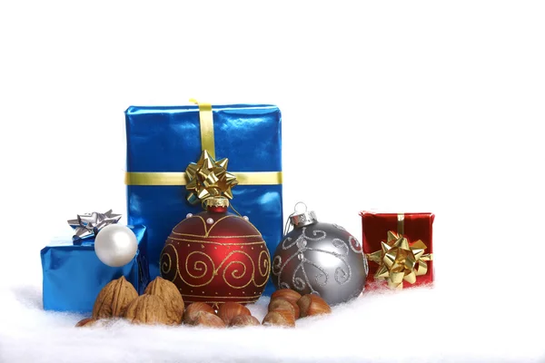 Julgran bollar, nötter och gåvor i snön — Stockfoto