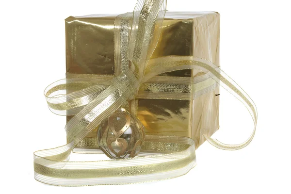 Um grande presente de Natal dourado com fita branca no fundo branco — Fotografia de Stock