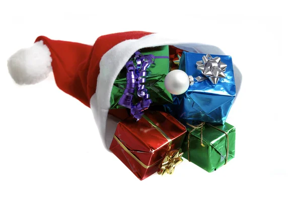 Muchos regalos de Navidad coloridos en una gorra de Santa Claus sobre fondo blanco —  Fotos de Stock
