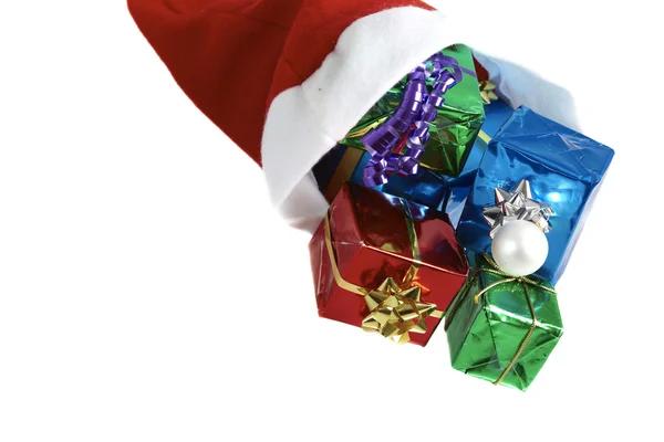 Molti regali di Natale colorati in un berretto di Babbo Natale su sfondo bianco — Foto Stock