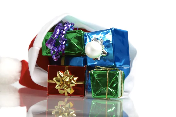 Muchos regalos de Navidad coloridos en una gorra de Santa Claus sobre fondo blanco —  Fotos de Stock