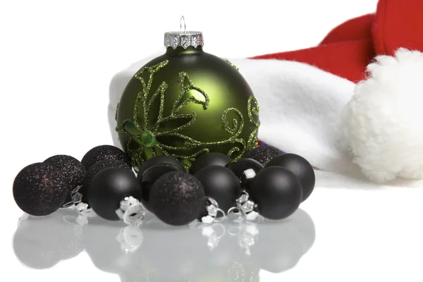 Santa claus cap and christmas balls mirrored on white background — Stock Photo, Image