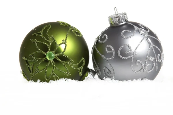 Duas bolas de árvore de Natal na neve no fundo branco — Fotografia de Stock