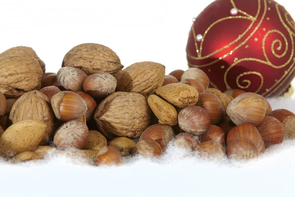 Weihnachtsbaumkugel und Nüsse auf weißem Hintergrund — Stockfoto