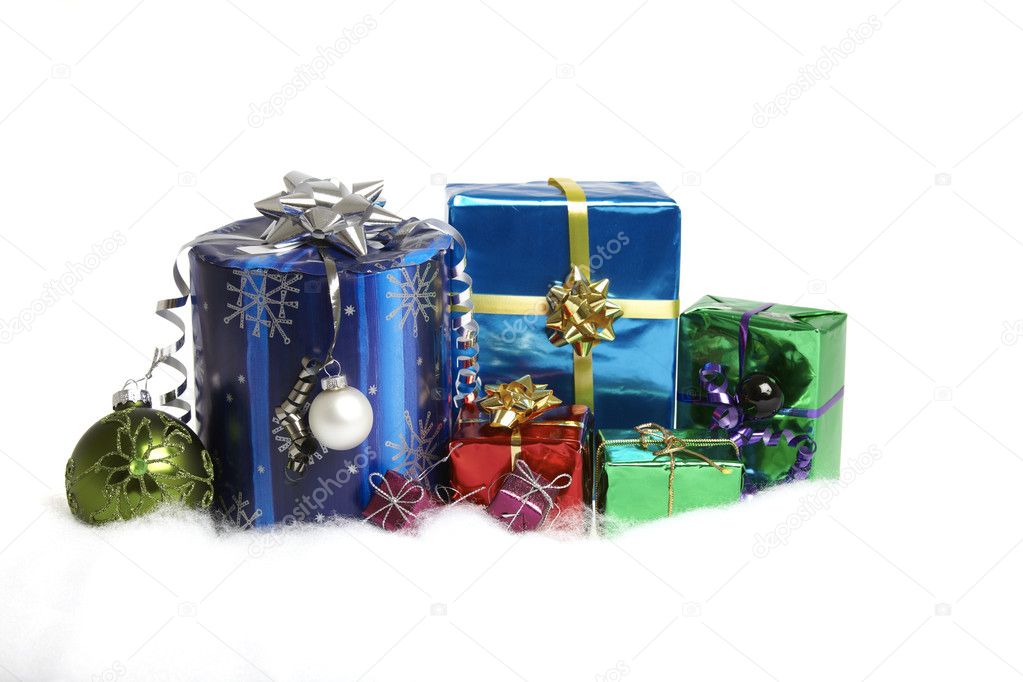 Many Christmas gifts packed in shiny colored paper on a white background