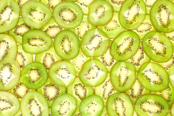 Owocowy tle plasterki kiwi caly — Zdjęcie stockowe