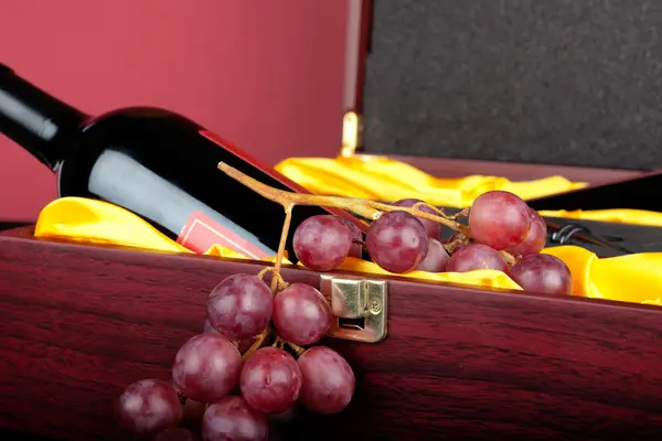 Μαχαιροπήρουνα και κρασιού κρασί μπουκάλι διακοσμημένο με καφέ Ξύλινη συσκευασία δώρου με σταφύλια — Φωτογραφία Αρχείου
