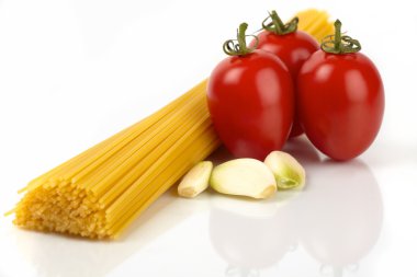 Spagetti makarna beyaz zemin üzerine sarımsak ve domates ile
