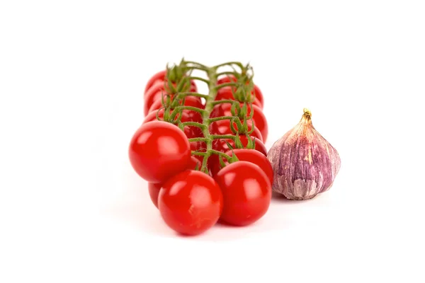 Resh cocktail tomatoes with a garlic onion in front of white background — Stock Photo, Image