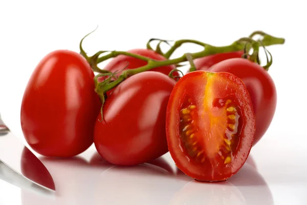 Tomates roma frescos con un cuchillo en frente de fondo blanco — Foto de Stock