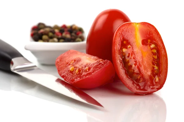 Tomates roma fraîches coupées avec des grains de poivre devant fond blanc — Photo