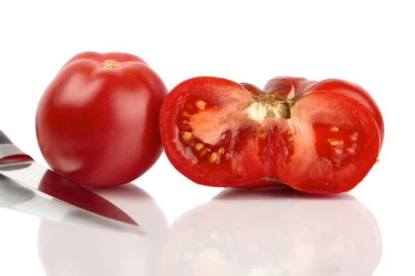 Два великих органічних помідори, одна ціла половина дзеркала перед білим тлом — стокове фото