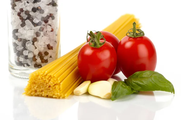 Špagety s rajčaty, bazalkou a česnekem na bílém pozadí — Stock fotografie