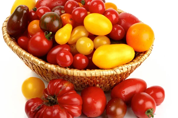 Many different organic tomatoes in the basket — Stock Photo, Image