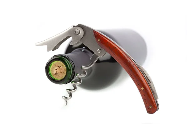 Corkscrew opened in front of a wine bottle — Stock Photo, Image