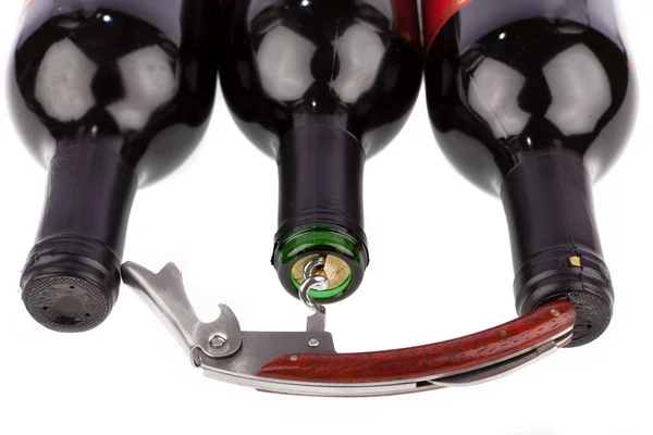 Korkskruv öppnas framför en tre vinflaska — Stockfoto