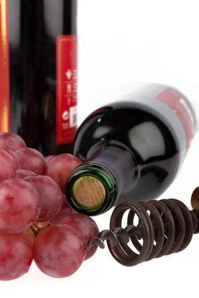 Due bottiglie di vino con cavatappi e uva su fondo bianco — Foto Stock
