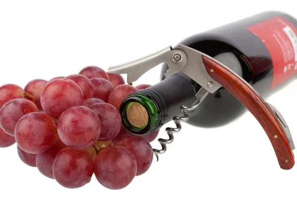 Bottiglia di vino con cavatappi e uva su fondo bianco — Foto Stock