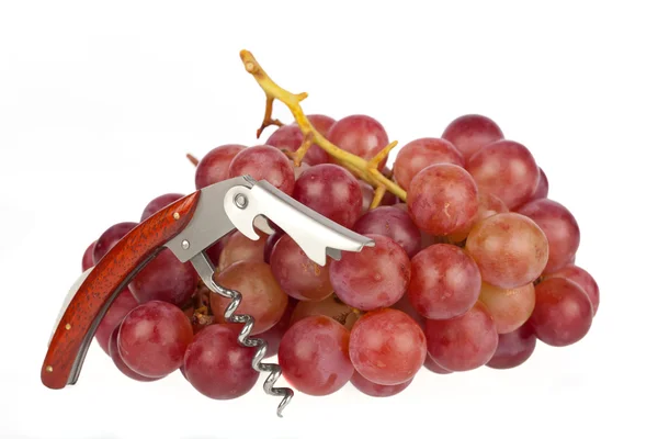 Corkscrew opened in front of grapes against white background — Stock Photo, Image