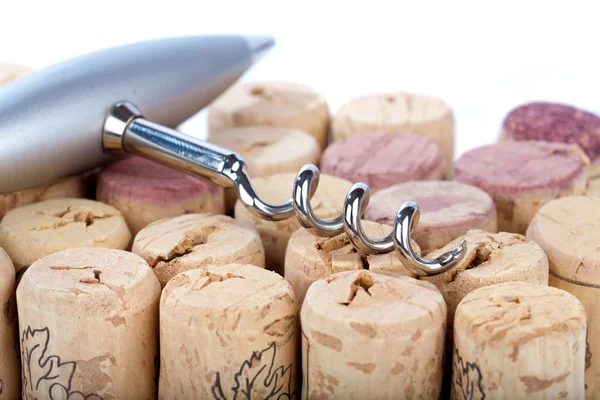 Noble metal corkscrew lies on many corks — Stock Photo, Image