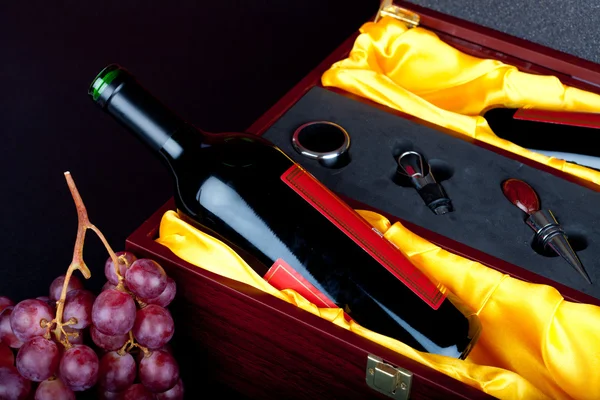 Cutlery and wine wine bottle decorated in brown wooden gift box with grapes — Stock Photo, Image