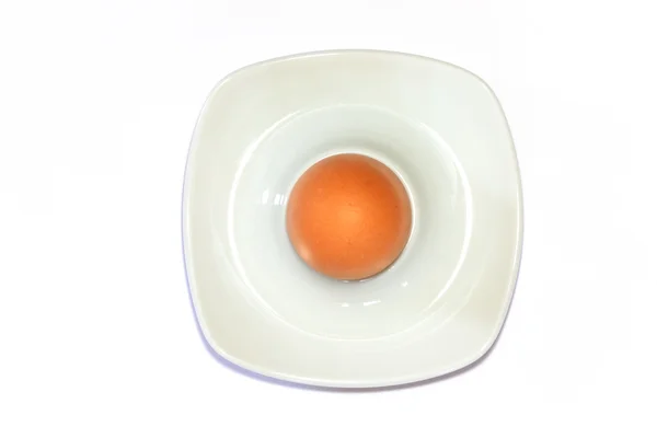 Коричневое яйцо в яичной чашке на белом фоне — стоковое фото