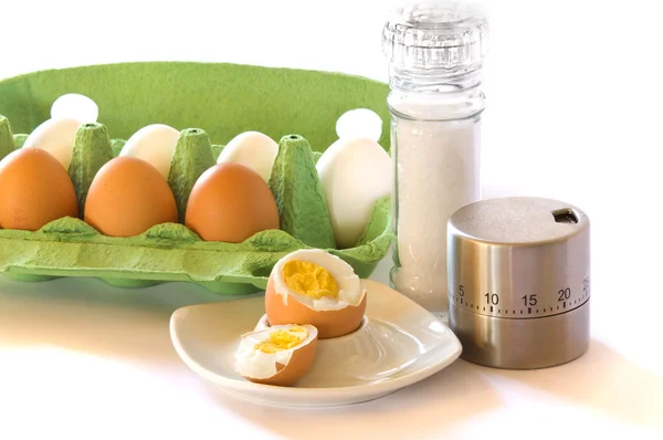 Chicken eggs and egg cups, eggtimer and salt mill — Stock Photo, Image