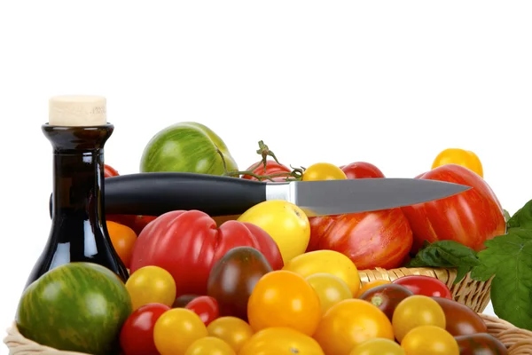 흰색 배경 앞에서 칼으로 바구니에 많은 유기농 토마토 — 스톡 사진