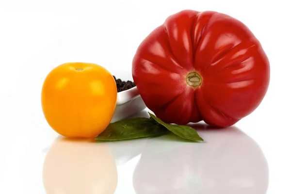 Two fresh organic tomatoes with pepper and basil leaves on a white background — ストック写真