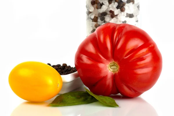 Dvě rajčata čerstvé organické soli a pepř mlýnek na bílém pozadí — Stock fotografie