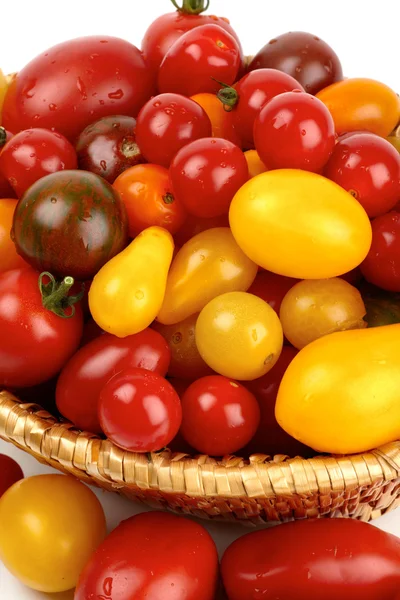 Many different organic tomatoes in the basket — Stock Photo, Image