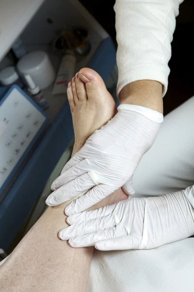 Un pédicure donne à une femme une réflexologie jambe et pied — Photo