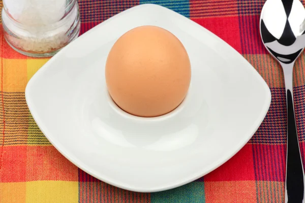 Huevo de desayuno en una taza de huevo con cuchara y molino de sal —  Fotos de Stock