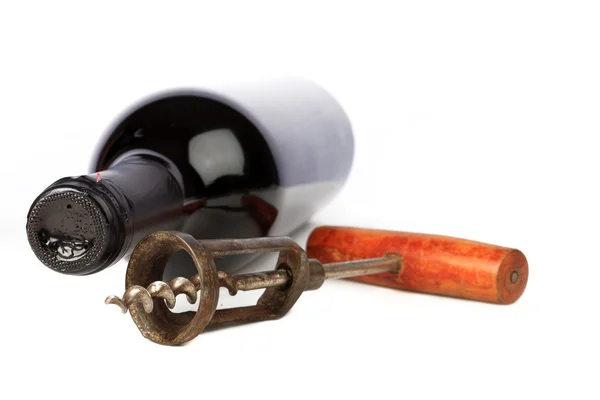 Old corkscrew with wood grip and wine bottle — Stock Photo, Image