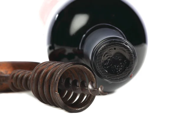 Old corkscrew with wood grip and wine bottle — Stock Photo, Image