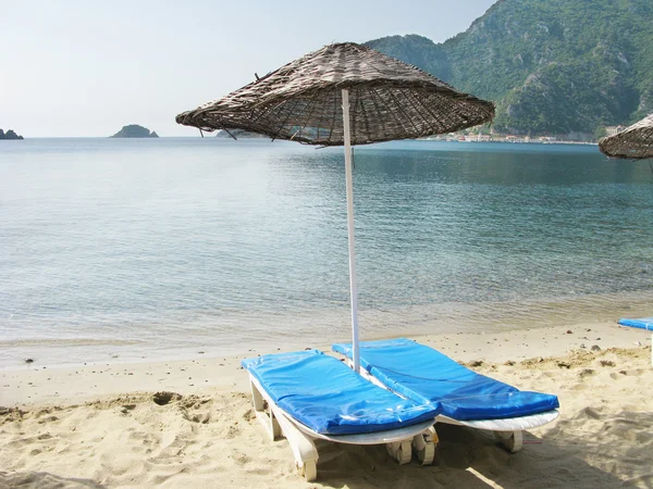 Пляж з сонячними батареями та шезлонгами — стокове фото