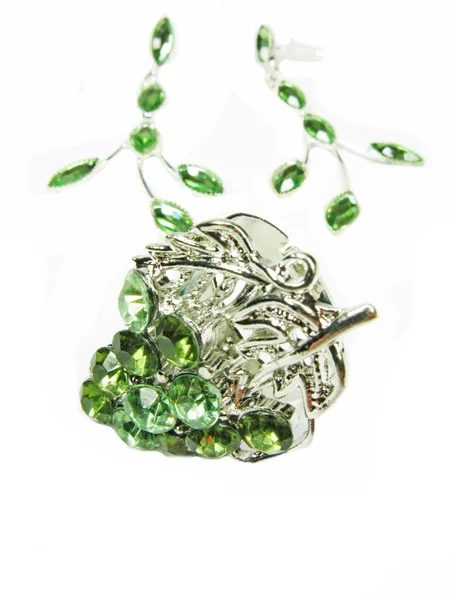 Takı yüzük ve küpeler ile parlak yeşil kristalleri koymak — Stok fotoğraf