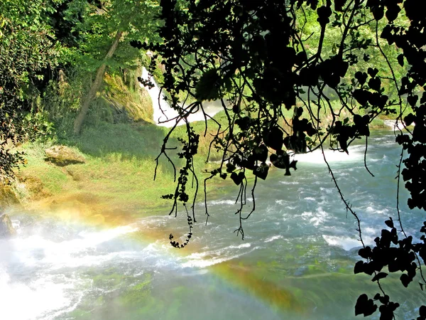 Cachoeira fora da gruta e arco-íris — Fotografia de Stock