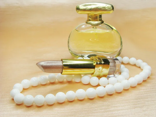 Biały brązowy szminka koraliki i perfumy — Zdjęcie stockowe