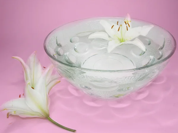 Água de spa com pétalas de flor de lírio — Fotografia de Stock