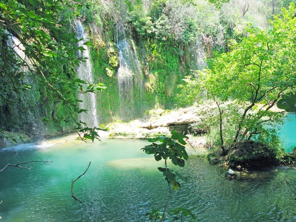 Waterfall cascade falling into blue lagoon — Stock Photo, Image