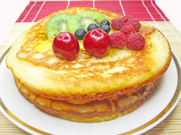 Sweet pancakes with fruits in syrup — Stock Photo, Image