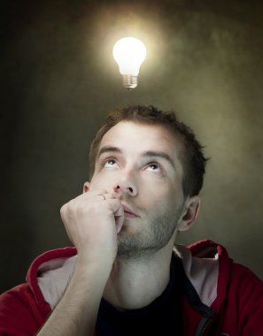 Young Man Having An Idea. Light Bulb Above His Head clipart