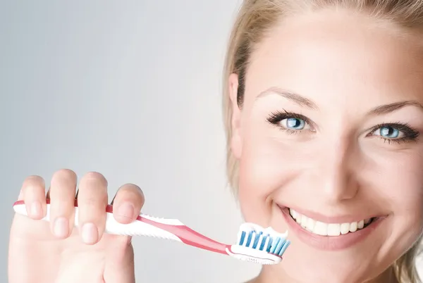 Felice giovane donna spazzolando i denti — Foto Stock