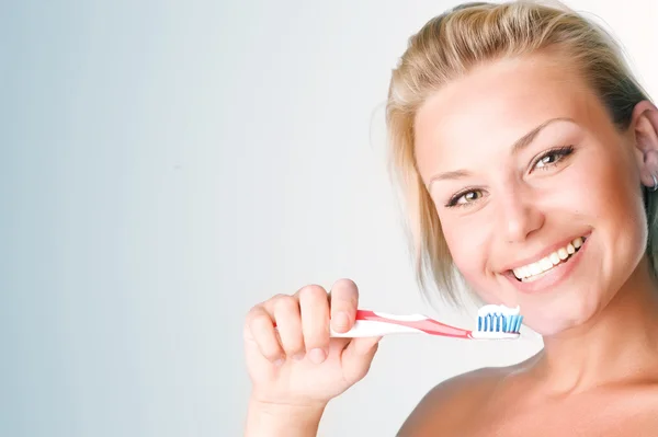 Felice giovane donna spazzolando i denti — Foto Stock