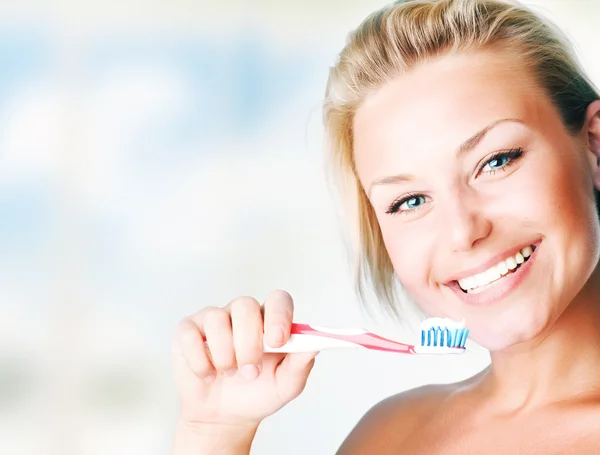 Feliz joven mujer cepillándose los dientes —  Fotos de Stock