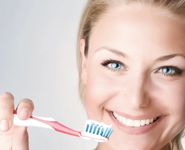 Счастливая молодая женщина чистит зубы — стоковое фото