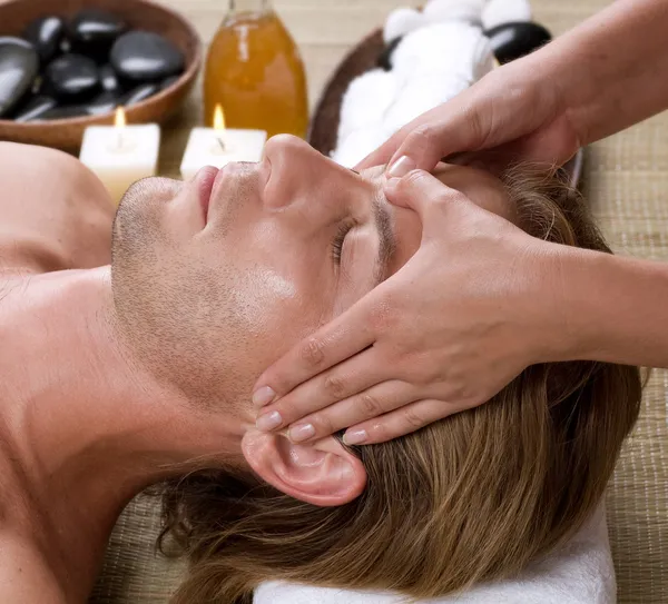 Spa. Homem jovem recebendo massagem facial — Fotografia de Stock