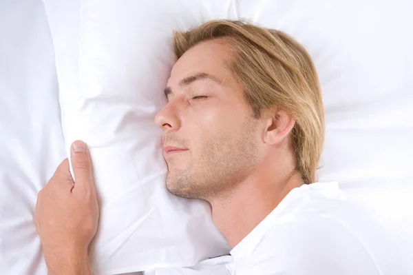 Jeune homme dormant dans son lit — Photo